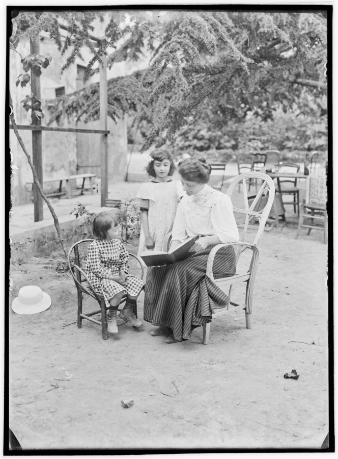 douard CORNET (1861-1930), Pierrot et milienne Weill entourent leur mre en train de leur lire un album,  [1908-1910],  photographie ngative sur plaque de verre (AMM, 115 FI 917)